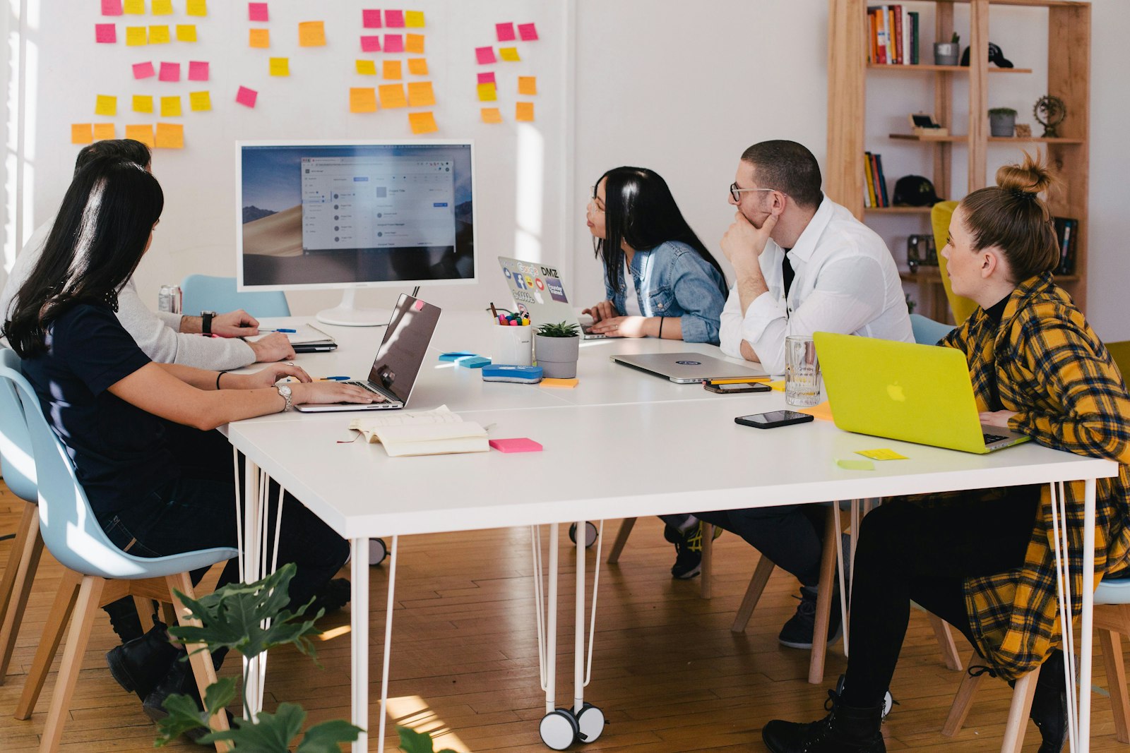 Team in einem Strategie-Meeting mit Sticky-Notes und Laptops