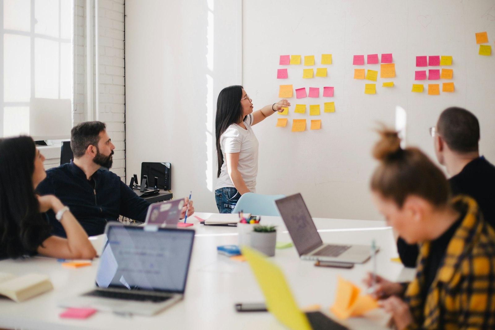 Workshop-Szene: Sticky-Notes an der Wand, Team bei der gemeinsamen Planung